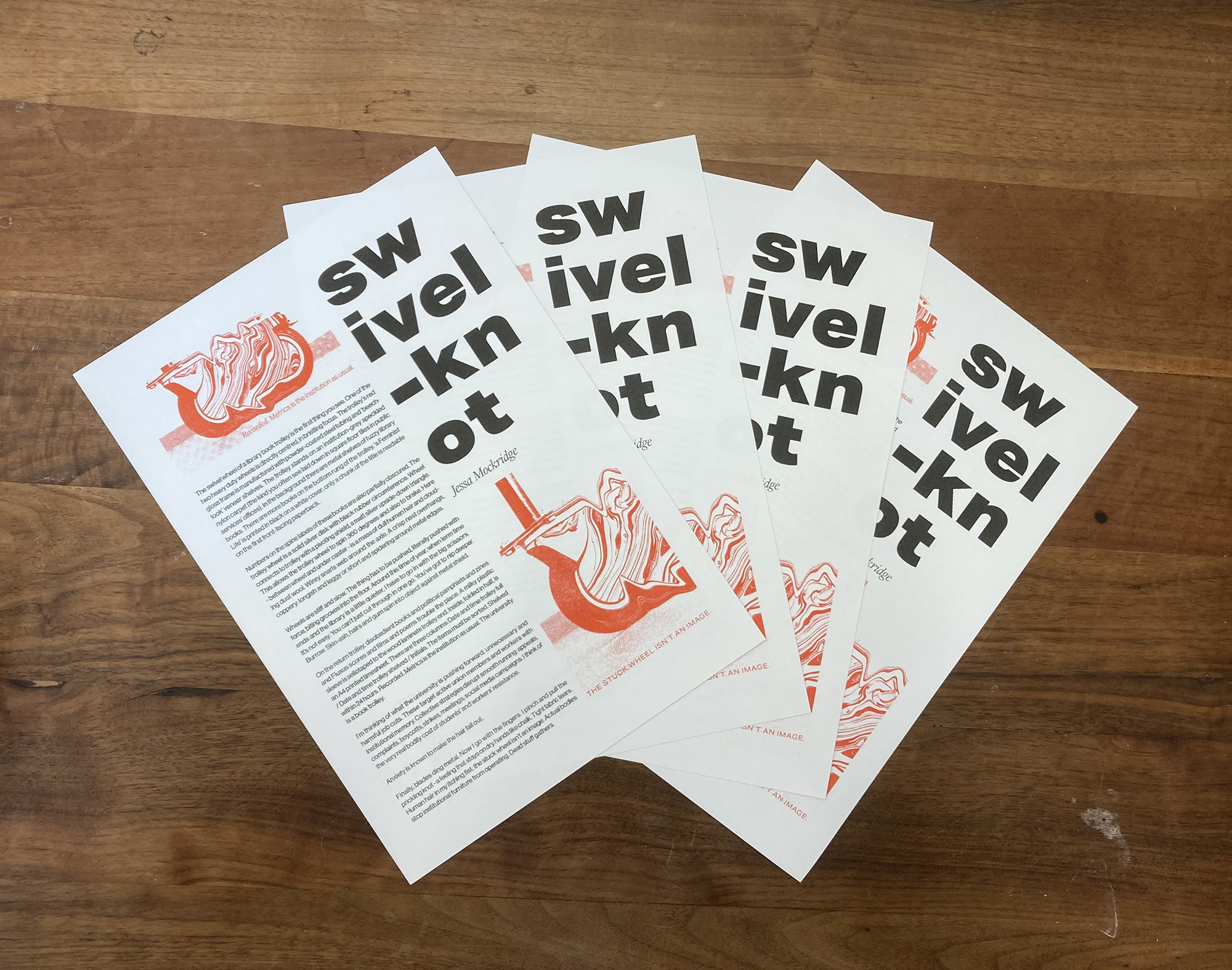 four posters fanned out on a wooden desk